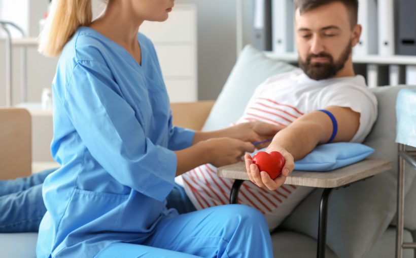 Pielęgniarka zakłada młodemu mężczyźnie opaskę uciskową na ramię, w celu pobrania próbki krwi. /Źródło: 123rf.com