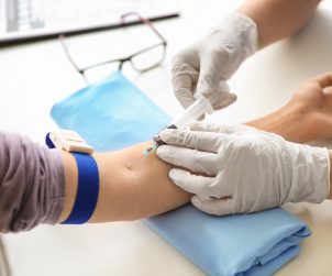 Pielęgniarka pobiera pacjentowi krew z żyły u zgięcia łokcia. /Źródło: 123rf.com