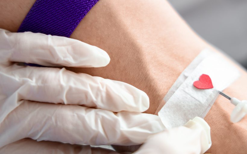 Pielęgniarz pobiera pacjentowi krew do celu analizy i diagnostyki, miejsce pobrania zakryte jest plastrem z naklejonym sercem. /Źródło: 123rf.com