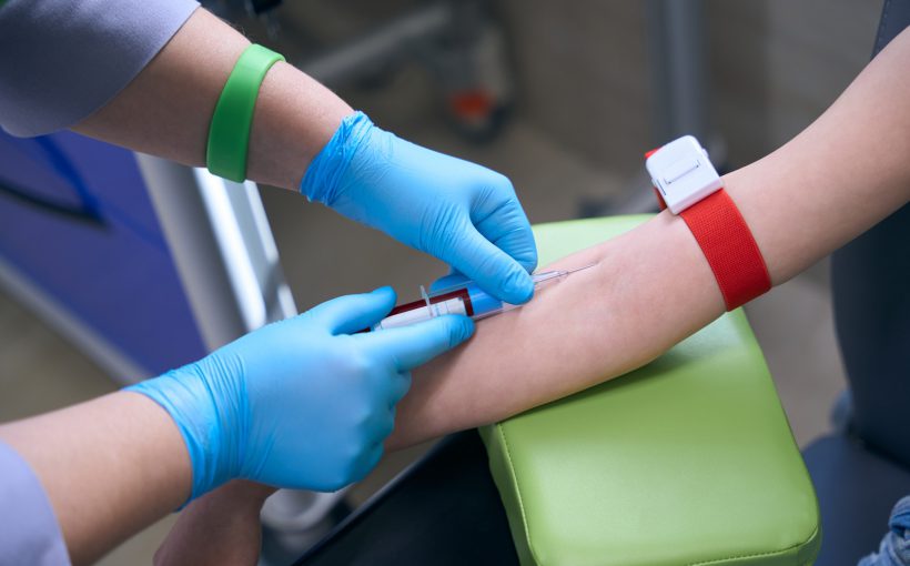 Pielęgniarka w sterylnych warunkach pobiera pacjentowi krew z żyły u ręki pacjentowi. /Źródło: 123rf.com