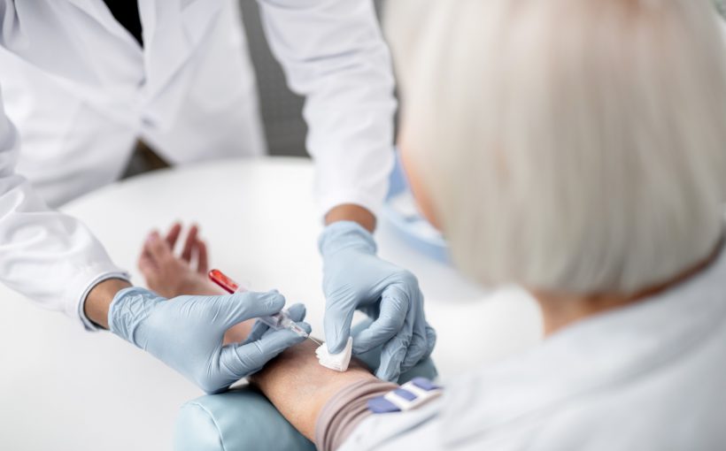 Pielęgniarz pobiera krew starszej pacjentce z żyły u ręki. /Źródło: 123rf.com