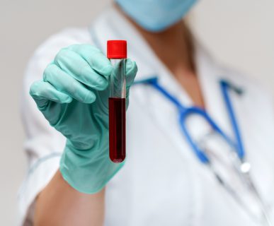 Młoda pielęgniarka trzyma w dłoni probówkę wypełnioną krwią. /Źródło: 123rf.com