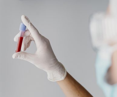 Diagnosta laboratoryjny trzyma w dłoni odzianej w białą, jednorazową rękawiczkę, fiolkę wypełnioną krwią pacjenta, pobraną w celu diagnostyki medycznej. /Źródło: 123rf.com