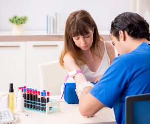 Młody pielęgniarz pobiera kobiecie krew w celu diagnostyki medycznej. /Źródło: 123rf.com