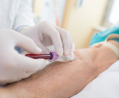 Pielęgniarka pobiera starszemu mężczyźnie krew z żyły u ręki. /Źródło: 123rf.com
