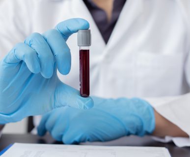 Analityk medyczny trzyma w dłoni probówkę wypełnioną próbką krwi w celu poddanie jej badaniom laboratoryjnym. /Źródło: 123rf.com