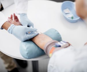 Pielęgniarz pobiera próbkę krwi starszemu mężczyźnie. /Źródło: 123rf.com