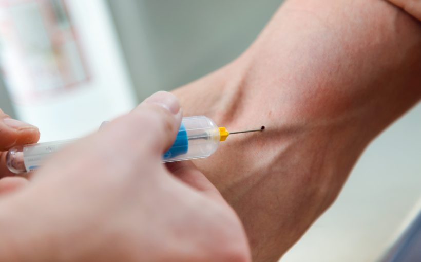 Pielęgniarka pobiera mężczyźnie krew z żyły u ręki. /Źródło: 123rf.com