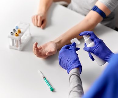 Pielęgniarka dezynfekuje wacik, aby następnie przemyć miejsce wkłucia, w celu sterylnego pobrania krwi. /Źródło: 123rf.com