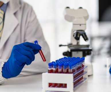 Technik laboratoryjny odkłada probówkę z krwią po poddaniu jej analizie i określeniu wyniku. /Źródło: 123rf.com