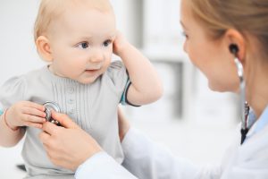 Lekarka bada małe dziecko za pomocą stetoskopu. /Źródło: 123rf.com