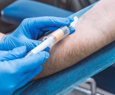 Pielęgniarka w sterylnych warunkach pobiera mężczyźnie krew. /Źródło: 123rf.com