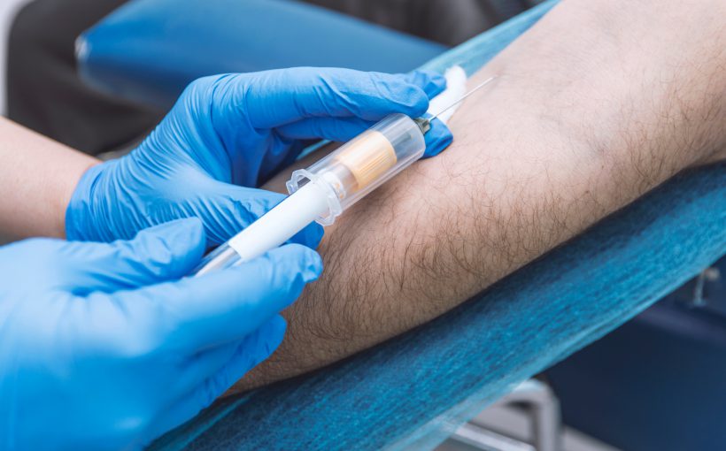 Pielęgniarka w sterylnych warunkach pobiera mężczyźnie krew. /Źródło: 123rf.com