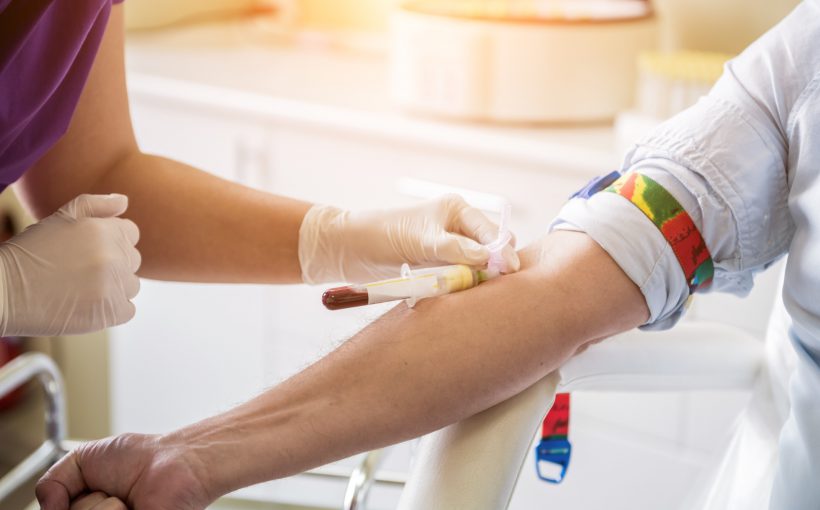Pielęgniarka pobiera młodemu mężczyźnie krew z żyły u ręki. /Źródło: 123rf.com