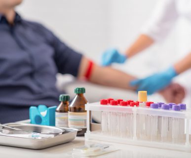Narzędzia medyczne, w tle których pielęgniarka pobiera mężczyźnie krew z żyły u ręki w celu diagnostyki laboratoryjnej. /Źródło: 123rf.com