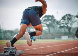 Młody mężczyzna biegnie sprintem po stadionie atletycznym. /Źródło: 123rf.com