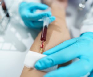 Pielęgniarka w sterylnych warunkach pobiera pacjentowi krew z żyły u zgięcia łokcia. /Źródło: 123rf.com