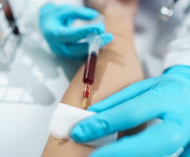 Pielęgniarka w sterylnych warunkach pobiera pacjentowi krew z żyły u zgięcia łokcia. /Źródło: 123rf.com