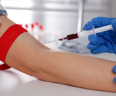 Pielęgniarka pobiera pacjentowi krew z żyły u ręki, na której założona jest opaska uciskowa. /Źródło: 123rf.com