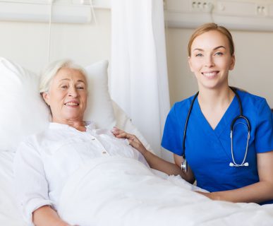 Lekarka i leżąca w łóżku pacjentka uśmiechają się do obiektywu. /Źródło: 123rf.com