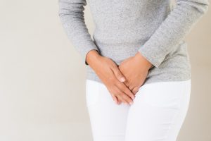 Kobieta w starszym wieku trzyma dłonie na podbrzuszu. /Źródło: 123rf.com