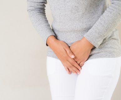Kobieta w starszym wieku trzyma dłonie na podbrzuszu. /Źródło: 123rf.com