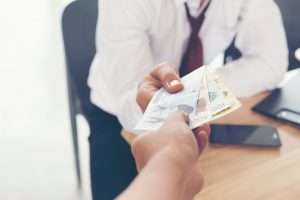 Pacjent wręcza lekarzowi łapówkę. /Źródło: 123rf.com