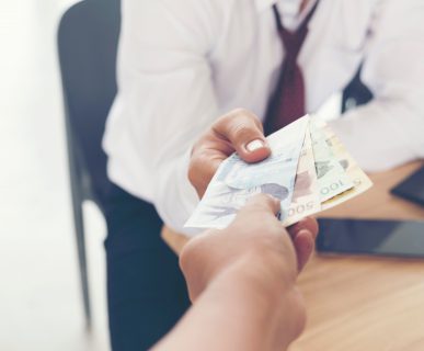 Pacjent wręcza lekarzowi łapówkę. /Źródło: 123rf.com