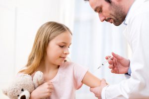 Doświadczony lekarz szczepi dziewczynkę szczepionką Gardasil. /Źródło: 123rf.com