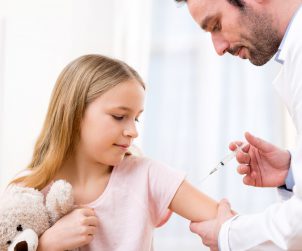 Doświadczony lekarz szczepi dziewczynkę szczepionką Gardasil. /Źródło: 123rf.com