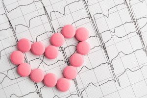 Zapis badania EKG, z ułożonym na nim sercem z tabletek. /Źródło: 123rf.com
