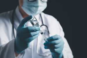 Lekarz neurolog pobiera lek z ampułki, w celu podania go pacjentowi. /Źródło: 123rf.com