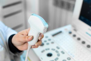 Lekarz radiolog przeprowadza pacjentowi badanie USG. /Źródło: 123rf.com