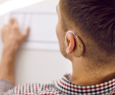 Młody mężczyzna z założonym aparatem słuchowym na ucho. /Źródło: 123rf.com