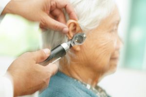 Lekarz przeprowadza starszej kobiecie badanie słuchu. /Źródło: 123rf.com