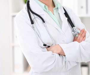 Lekarka stoi ubrana w biały lekarski fartuch, na szyi ma powieszony stetoskop. /Źródło: 123rf.com