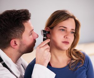 Lekarz przeprowadza pacjentce badanie słuchu. /Źródło: 123rf.com