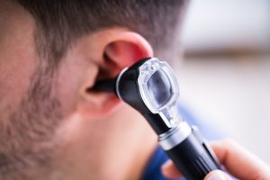 Lekarz badający uszy pacjenta za pomocą otoskopu. /Źródło: 123rf.com