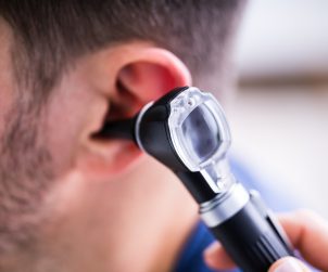 Lekarz badający uszy pacjenta za pomocą otoskopu. /Źródło: 123rf.com