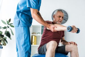 Lekarz rehabilitant przeprowadza terapię z pacjentem. /Źródło: 123rf.com