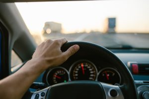 Mężczyzna prowadzi auto jadąc po autostradzie. /Źródło: 123rf.com
