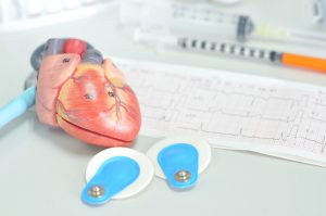 Anatomiczny model serca położony na biurku lekarskim. /Źródło: 123rf.com