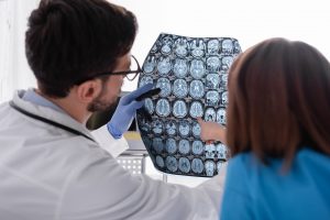 Doktor omawia z pacjentką jej wynik tomgrafii komputerowej głowy podczas konsultacji neurologicznej w przychodni. /Źródło: 123rf.com