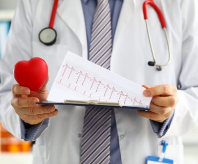Lekarz trzyma w dłoni wydruk EKG pacjenta. /Źródło: 123rf.com