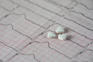 Trzy tabletki w kształcie serca leżą na opisie EKG pacjenta. /Źródło: 123rf.com