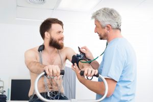 Lekarz przeprowadza próbę wysiłkową pacjentowi z chorobą kardiologiczną. /Źródło: 123rf.com