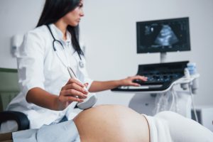 Lekarz ginekolog przeprowadza badanie diagnostyczne płodu pacjentce w ciąży. /Źródło: 123rf.com