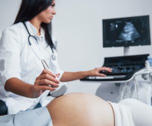 Lekarz ginekolog przeprowadza badanie diagnostyczne płodu pacjentce w ciąży. /Źródło: 123rf.com