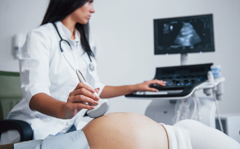 Lekarz ginekolog przeprowadza badanie diagnostyczne płodu pacjentce w ciąży. /Źródło: 123rf.com