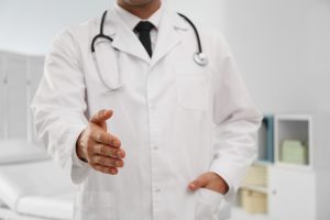 Profesjonalny lekarz wyciąga dłoń na przywitanie pacjentowi. /Źródło: 123rf.com